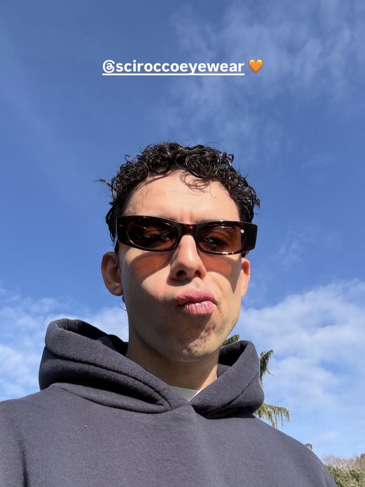 Cliente Scirocco con occhiali tartarugati sotto il cielo azzurro