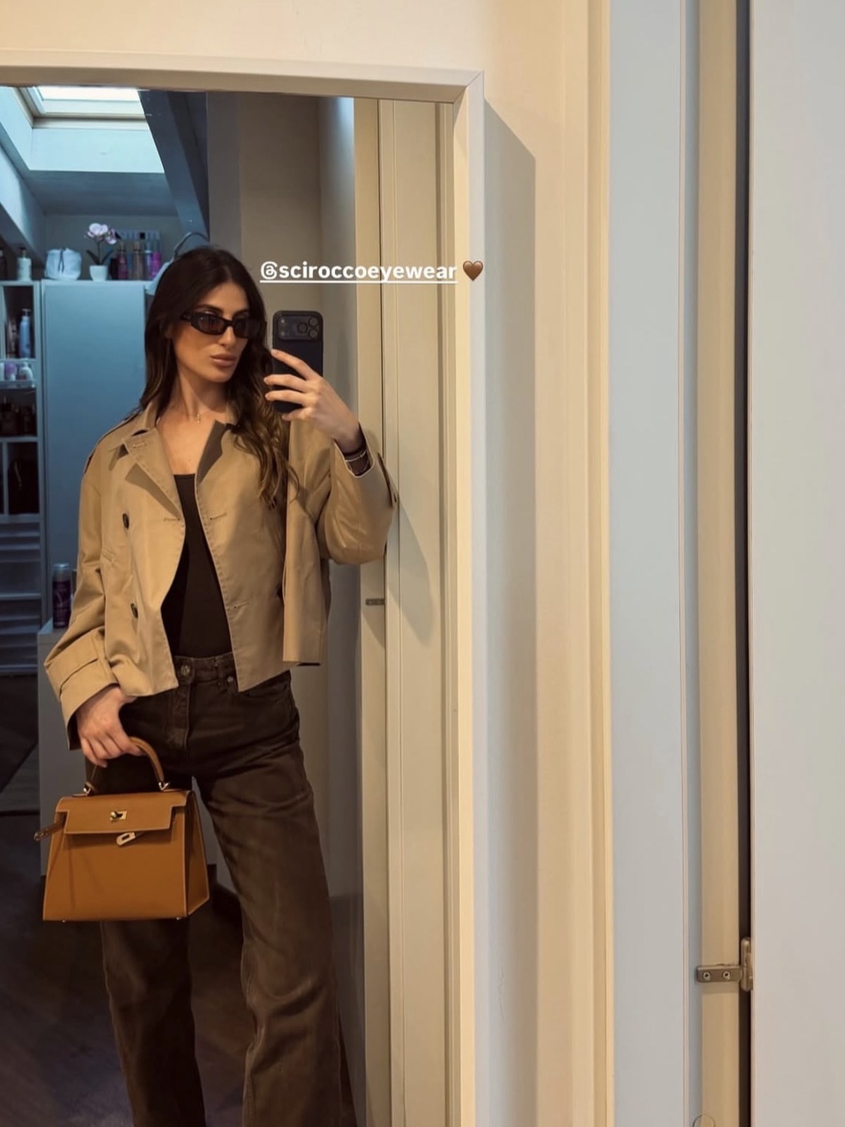 Cliente Scirocco allo specchio con trench e borsa